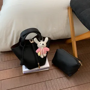 Black PU leather bucket bag with matching pouch and cute bunny pendant for women daily use.