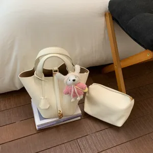 Chic beige bucket handbag set with matching pouch and cute bunny charm for women daily fashion style.