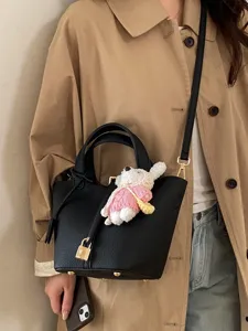 Stylish black leather bucket bag for women with classic padlock design and cute charm pendant.