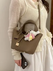 Premium brown leather bucket handbag with padlock and crochet charm for women