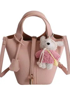 Pink leather bucket bag for women, stylish crossbody handbag with cute bear pendant and lock.