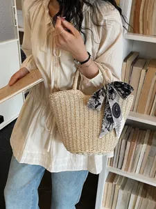 Elegante borsa in paglia intrecciata da donna per vacanze estive al mare con nastro chic