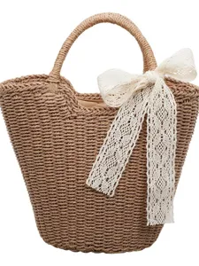 Elegante borsa in paglia intrecciata con un delicato fiocco in pizzo bianco per il mare.
