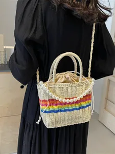 Chic straw woven bucket bag with rainbow stripes and elegant pearl chain, perfect for summer.