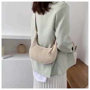 Detailed view of stylish straw woven underarm shoulder bag with leather trim for spring and summer.