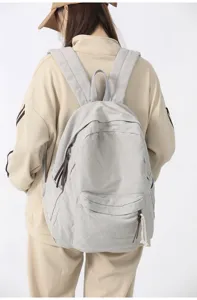Vue détaillée du sac à dos en toile décontracté avec poches zippées et bretelles solides.