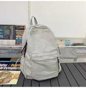 Sac à dos en toile détail, style scolaire décontracté, sac à double bandoulière durable pour usage.