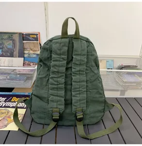 Vue détaillée du sac à dos en toile verte uni montrant les bretelles réglables au dos.