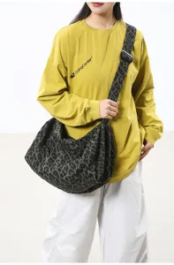 Leopard print canvas crossbody bag detail, featuring wide strap and large capacity.