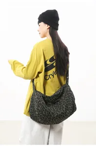 Detailed view of a stylish large capacity slouchy leopard canvas crossbody shoulder bag.
