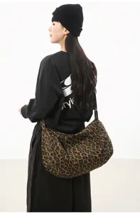 Detailed view of the stylish leopard print canvas crossbody bag, featuring large capacity design.