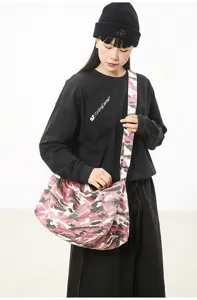 Detail view of the pink camo canvas crossbody bag, featuring spacious casual commuter design.