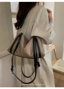 Detalle de bolso de hombro retro de ante marrón con correas negras y estilo chic minimalista.
