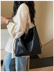 Detail view of large capacity black soft leather hobo shoulder bag for daily casual commute.