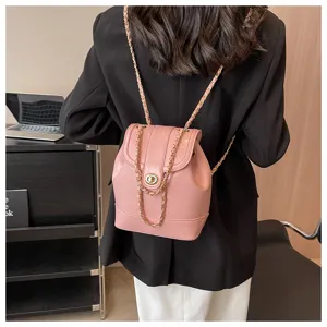 Sac à dos rose en cuir pour femme avec lanières en chaîne et fermeture métallique chic.