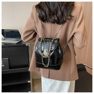 Sac à dos noir en cuir verni pour femme, élégant petit sac à bandoulière chic et mode.