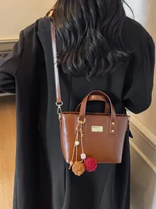 Stylish brown bucket bag for women, versatile PU leather crossbody handbag with cute charms.