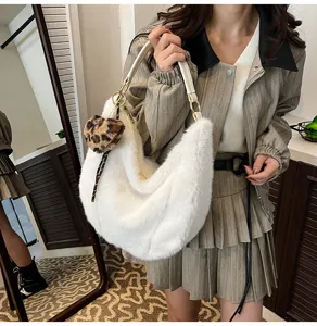 Fluffy white underarm shoulder bag for women, cozy plush winter handbag with cute pom-pom.