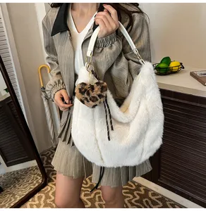 Close-up view of the fluffy white shoulder bag showing its chic leopard heart pendant.