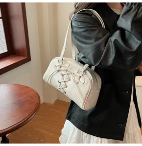 Detailansicht einer eleganten weißen Schultertasche für Damen mit modischem Schnürdesign.