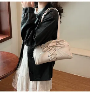 Detailansicht der cremeweißen Schultertasche mit schicker Schnürung und Lederoptik.