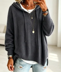 Detail shot of the loose hooded knit sweater, featuring long sleeves and cozy texture.