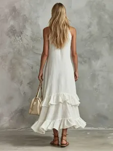 Detailansicht eines eleganten weißen ärmellosen Maxikleides mit Rüschen, Tasche und Sandalen.