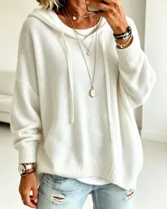 Close-up detail of the white knitted hooded sweater featuring cozy drawstring and ribbed hem.