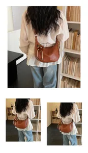 Detail shot of the stylish brown shoulder bag with cute plush charm, showing its texture and wear.