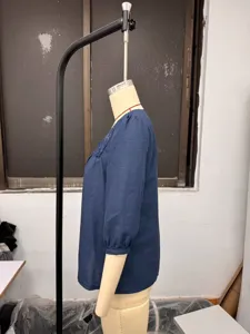 Side view detail of the blue linen blend top showcasing square neck and elegant lace splicing.