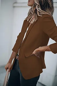 Close-up detail of the stylish brown blazer jacket showing the lapel and sleeve design.