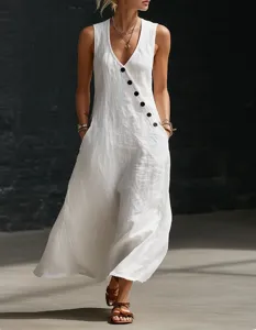 Detail shot of white sleeveless maxi dress with diagonal black buttons and deep V-neck.