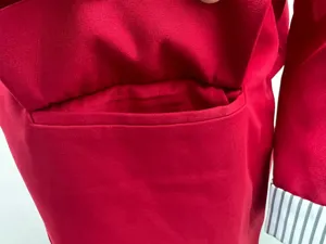 Red blazer detail shot showcasing pocket and striped cuff design for women fashion.