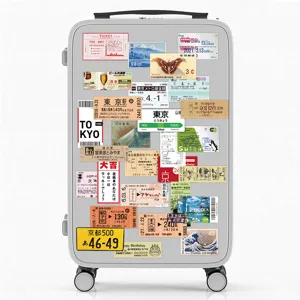 Grey hardside luggage featuring vintage Japanese travel tickets and scenic stamp stickers.