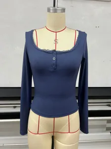Détail de haut à manches longues côtelé avec col carré en dentelle en bleu foncé.