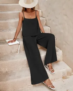 Detail view of women's solid color camisole top and wide leg pants set on stone stairs.