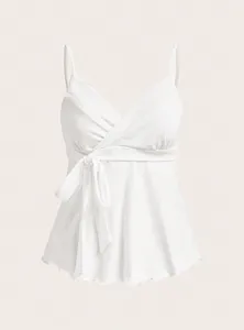 Close-up detail of white V-neck wrap camisole featuring tie waist and cute ruffled hem.