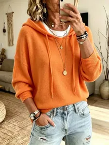 Detail view of the orange knit hooded sweater with long sleeves and drawstring, casual style.