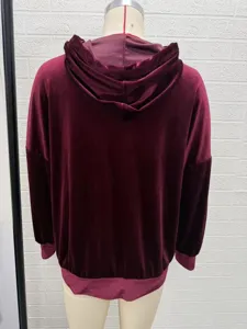 Back detail view of women's burgundy velvet long sleeve hooded cardigan jacket cozy fabric.
