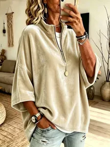 Dettaglio del top in velluto da donna con mezza zip, tessuto morbido e maniche a tre quarti.