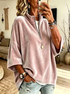 Vista dettagliata del top in velluto con mezza zip in rosa, che mette in mostra la sua morbida.