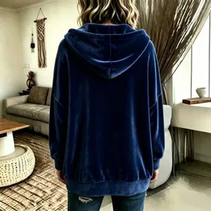 Detail view of a soft blue velvet hooded sweatshirt, casual long sleeve back look in room.