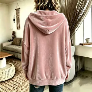 Detailed back view of the pink velvet hoodie showing soft fabric texture and cozy room style.