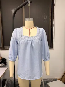 Detail shot of light blue square collar blouse, lace patchwork neckline, 3/4 sleeves.