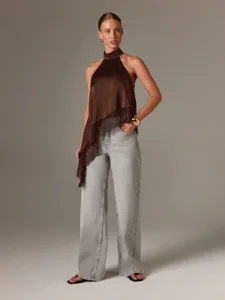 Detailansicht des braunen Satin Haltertop für Damen mit asymmetrischer Spitze und Jeans.
