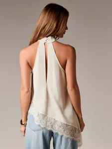 Detailansicht eines ärmellosen Satin-Haltertops mit asymmetrischem Spitzensaum und Knopfverschluss.