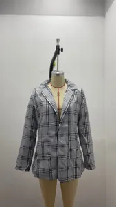 Detail view of the black and white plaid blazer, featuring lapel collar and long sleeves.
