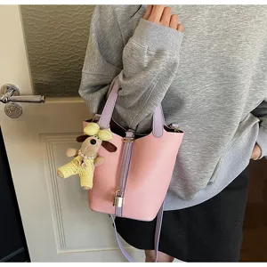 Pink leather bucket bag detail view, sweet style shoulder bag with lock and cute charm.
