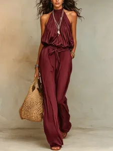 Burgundy halter jumpsuit detail, stylish sleeveless resort wear with tie waist and wide legs.
