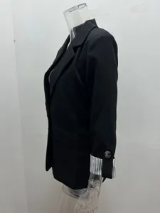 Detailed view of women's black casual blazer featuring rolled striped cuffs and classic lapel.